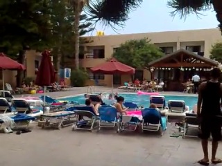 a group of guys are jumping naked into a hotel pool